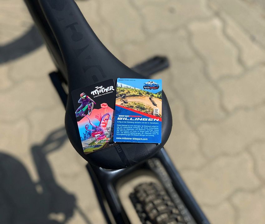 Tickets der Bikeparks Winterberg & Willingen liegen zusammen auf einem Fahrradsattel